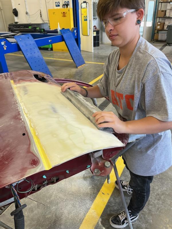 Zane doing block sanding to repair a car door
