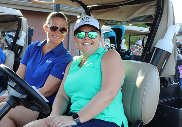 photo of two women in golf cart
