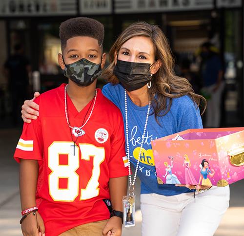 photo of boy in Chiefs jersey with teacher