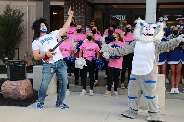 photo of tiger mascot and man playing guitar