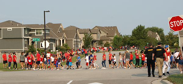 photo of line of people walking in neighborhood