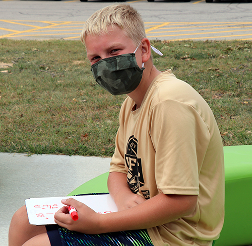 photo of boy doing math outside