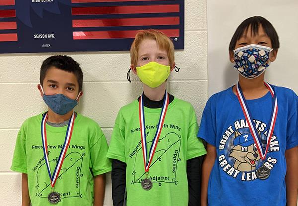 photo of three students wearing medals