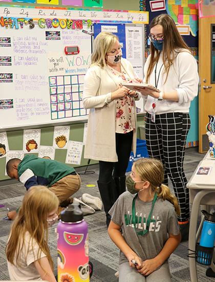 photo of two teachers conferring in classroom