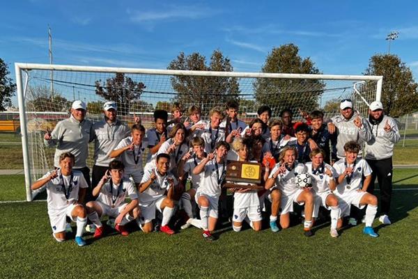 photo of the Olathe West boys' soccer team with trophy