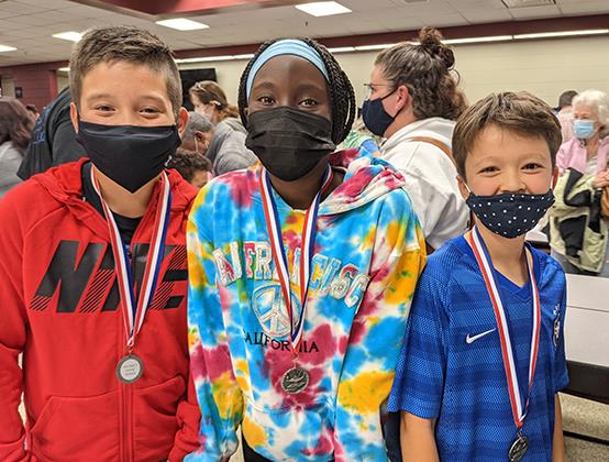 photo of three students wearing medals