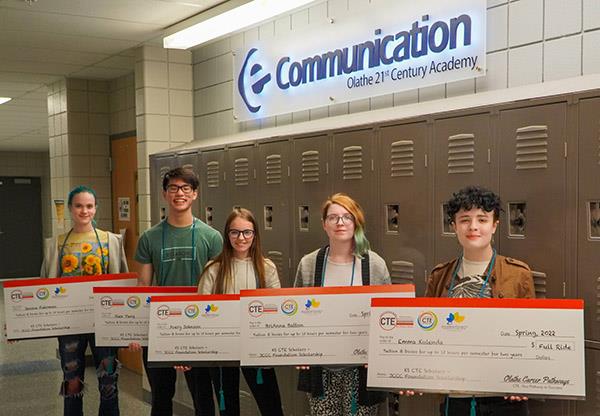five students hold mock checks