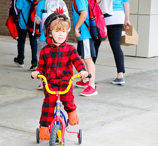 boy wearing red flannel and sitting on tricycle