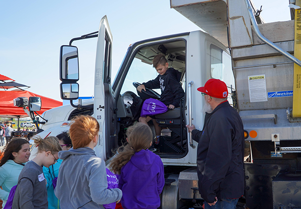 boy gets out of dump truck cab