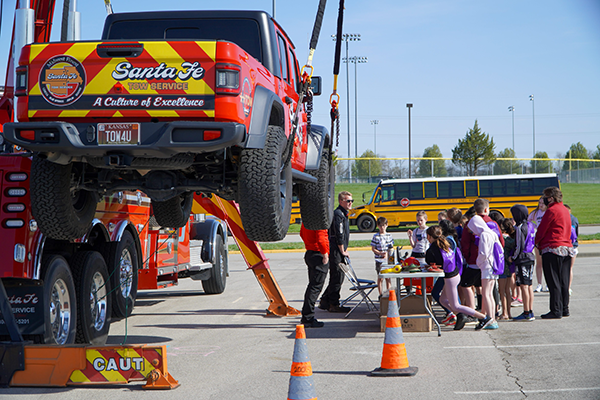 big truck hangs from straps as students watch