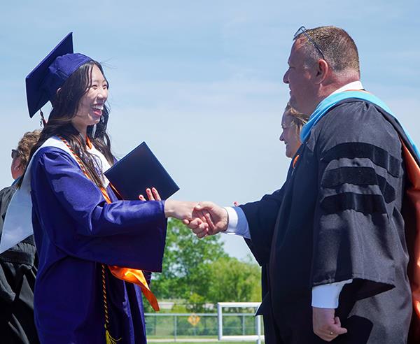 girl shakes hands with superintendent on stage