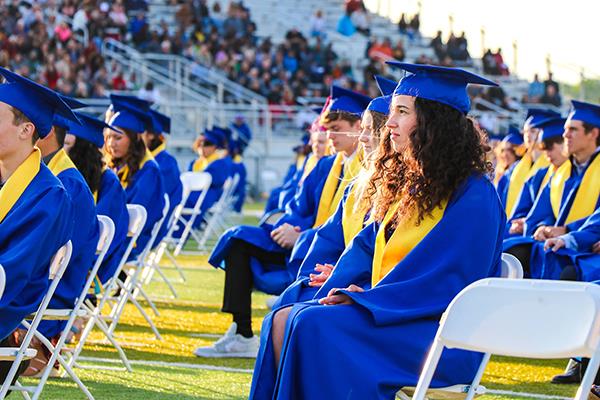 students seated on football field