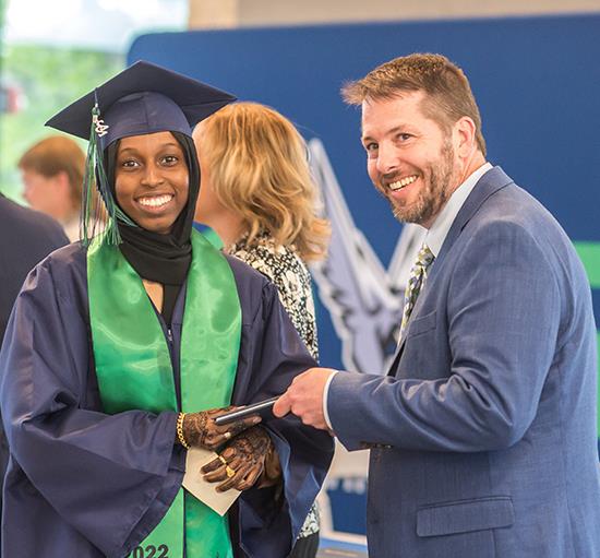principal hands diploma to student