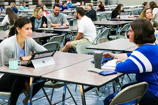 Photo of two educators conversing.