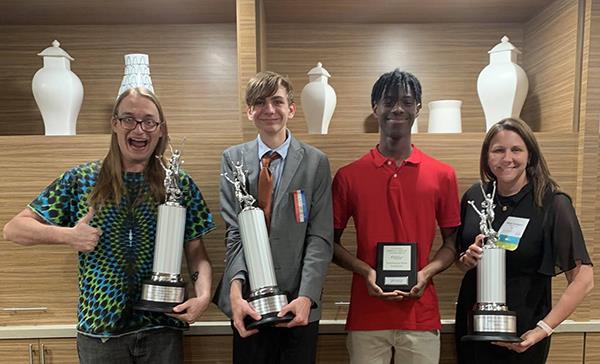 students and teacher hold debate awards