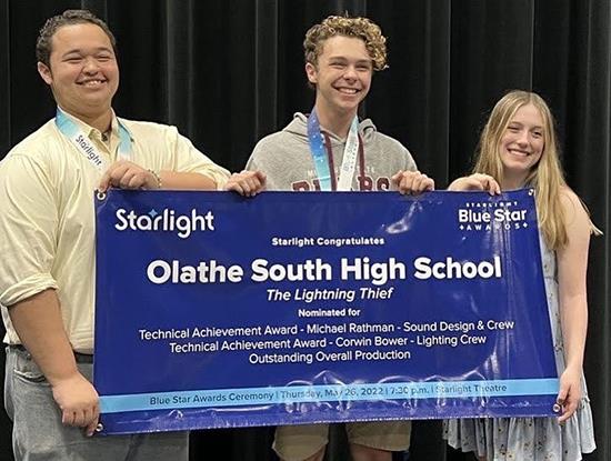 three students hold award banner