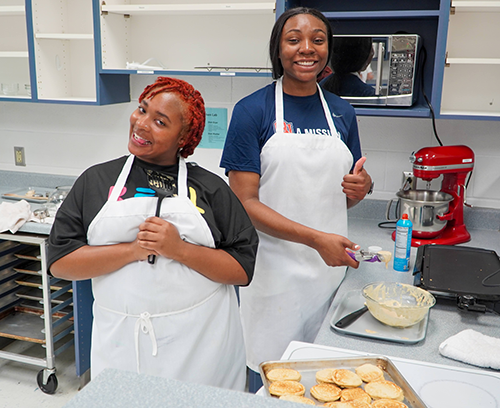 two girls prepare to make more pancakes