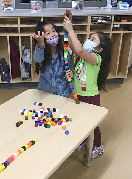 two students stack blocks together