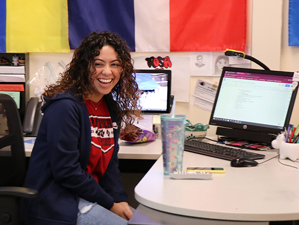 woman seated at desk, laughing