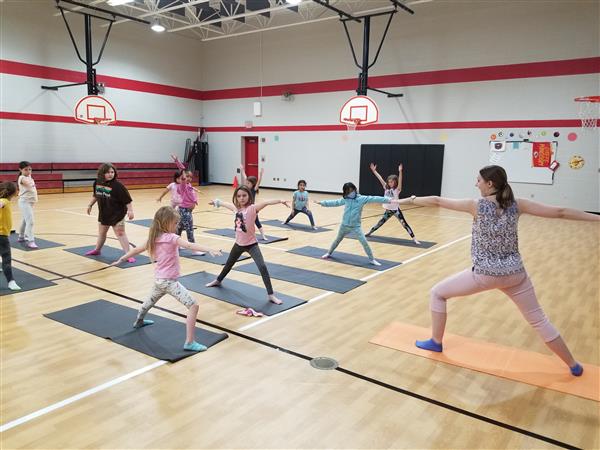 Students learn different yoga poses.