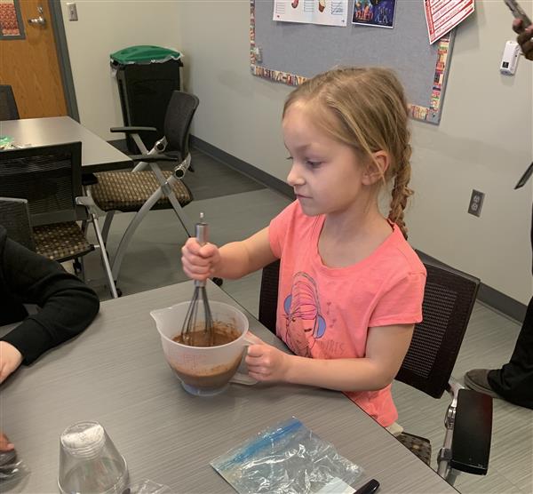 Student stirs the batter to make brownies.