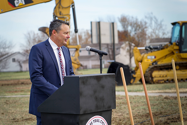 J.J. Libal at podium, heavy equipment in background