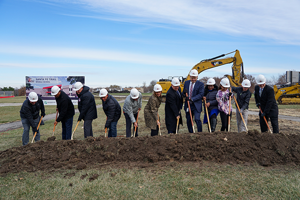 group of people shovel dirt during ceremony