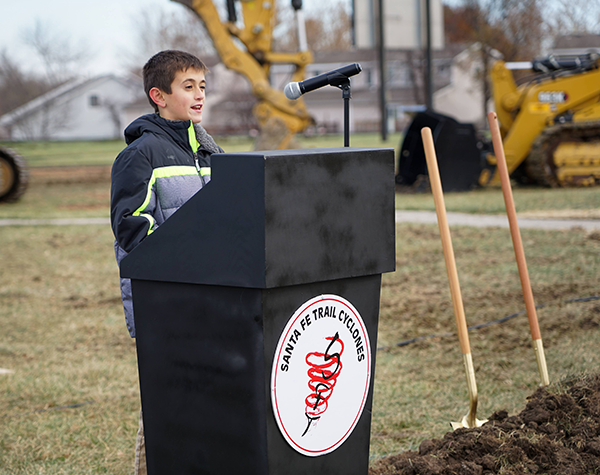 boy stands at podium at construction site