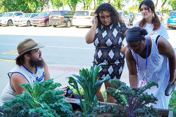 students listen to their instructor in the garden