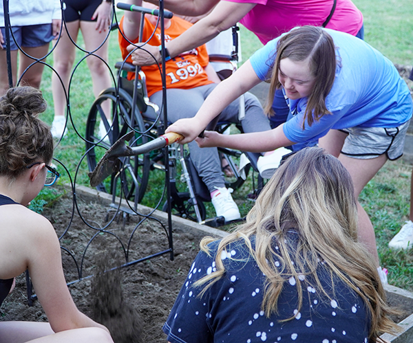 girl turns over shovel full of dirt