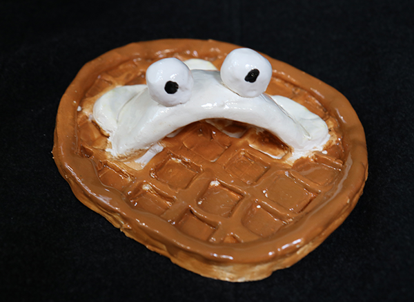 ceramic waffle with whipped topping made to look like a monster