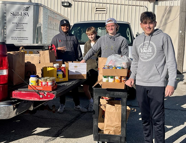 students load canned and boxed food into pickup