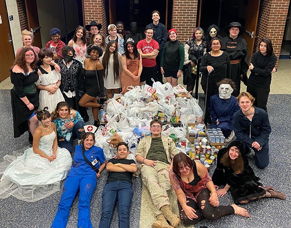 theater students and a pile of donated food items
