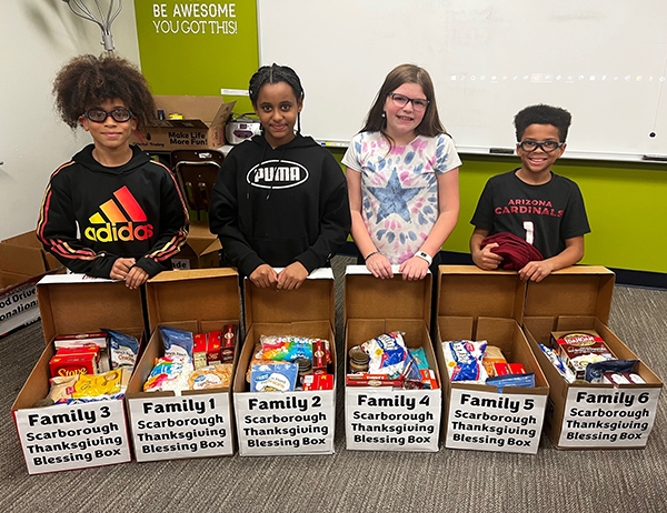students with boxes of traditional Thanksgiving food