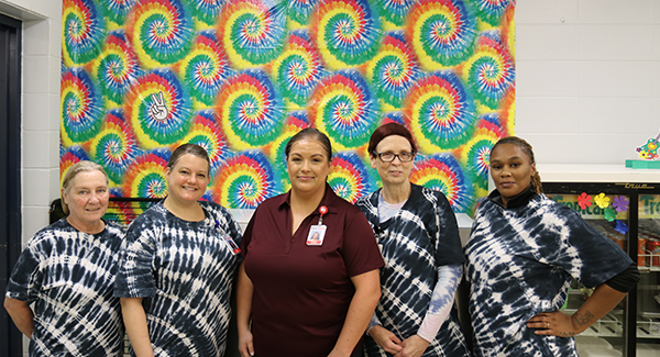 kitchen staff in front of tie-dyed background