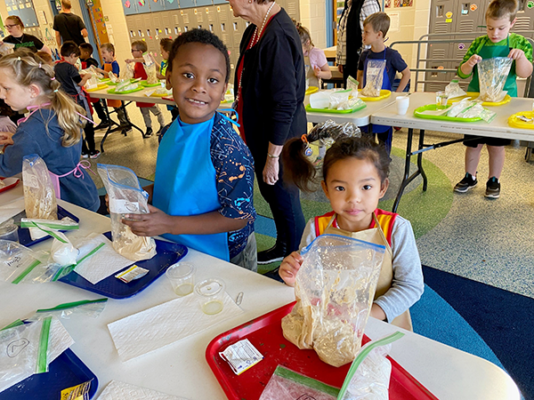 students hold plastic bags of pizza dough