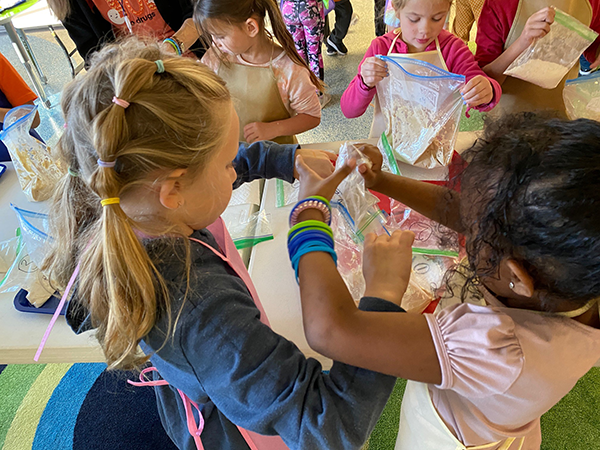 students measure and pour flour into bags