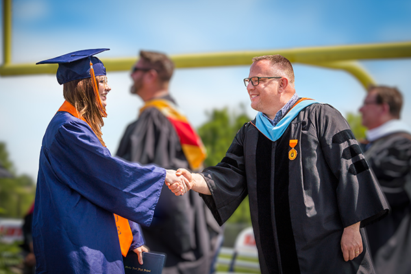 superintendent and senior shake hands
