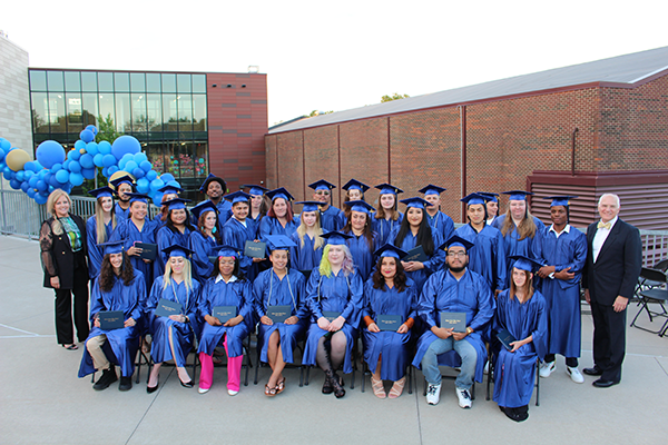 group of graduates hold their diplomas
