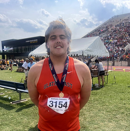 boy wearing shot put state champ medal