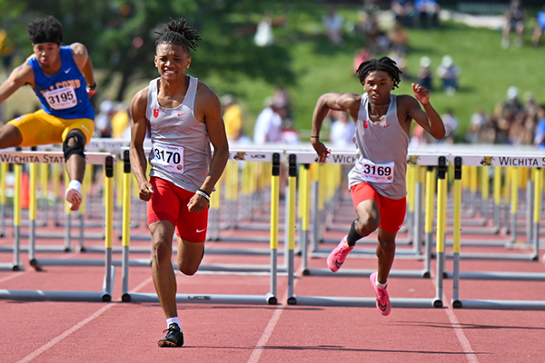 boys running hurdles on track