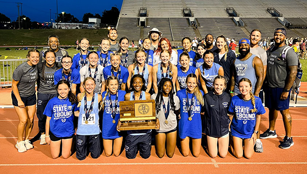 girls track team and their trophy
