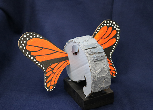 cardboard creature with elephant head and butterfly wings