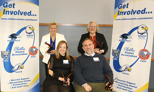 three women and one man pose for photo with their awards