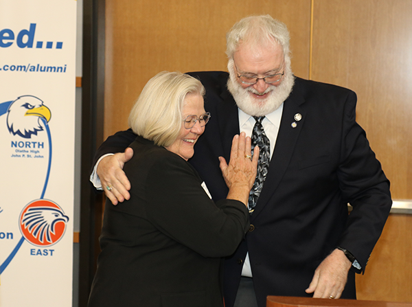 woman and man hug at podium