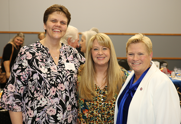three women pose for camera