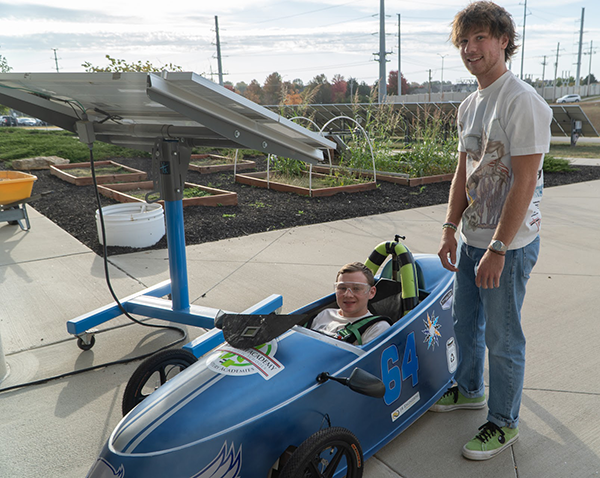two teenagers with their electric car