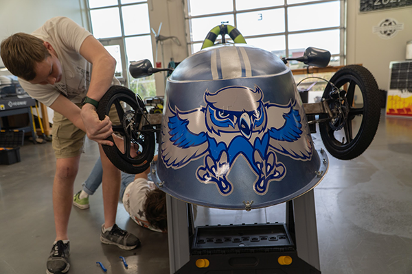 students work on electric race car