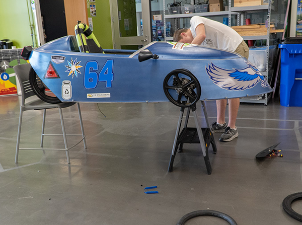 student works on electric race car