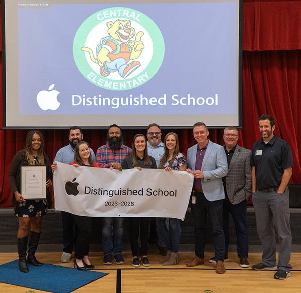 school officials hold banner announcing award